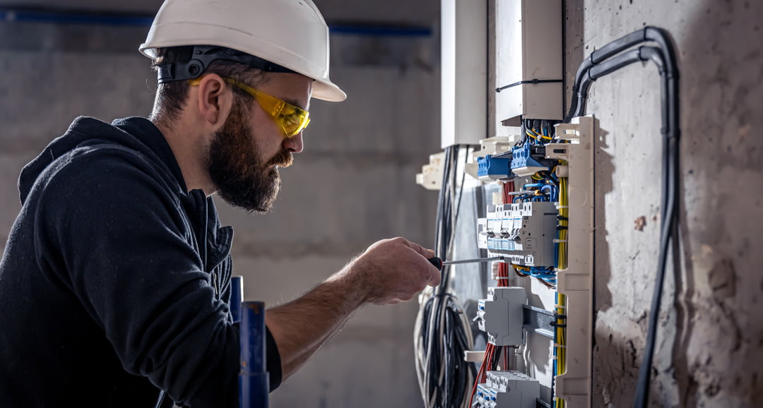 Electrician working on fuse box installation