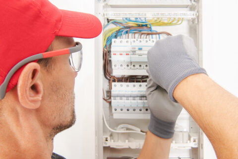 Electrician working on a circuit breaker box.
