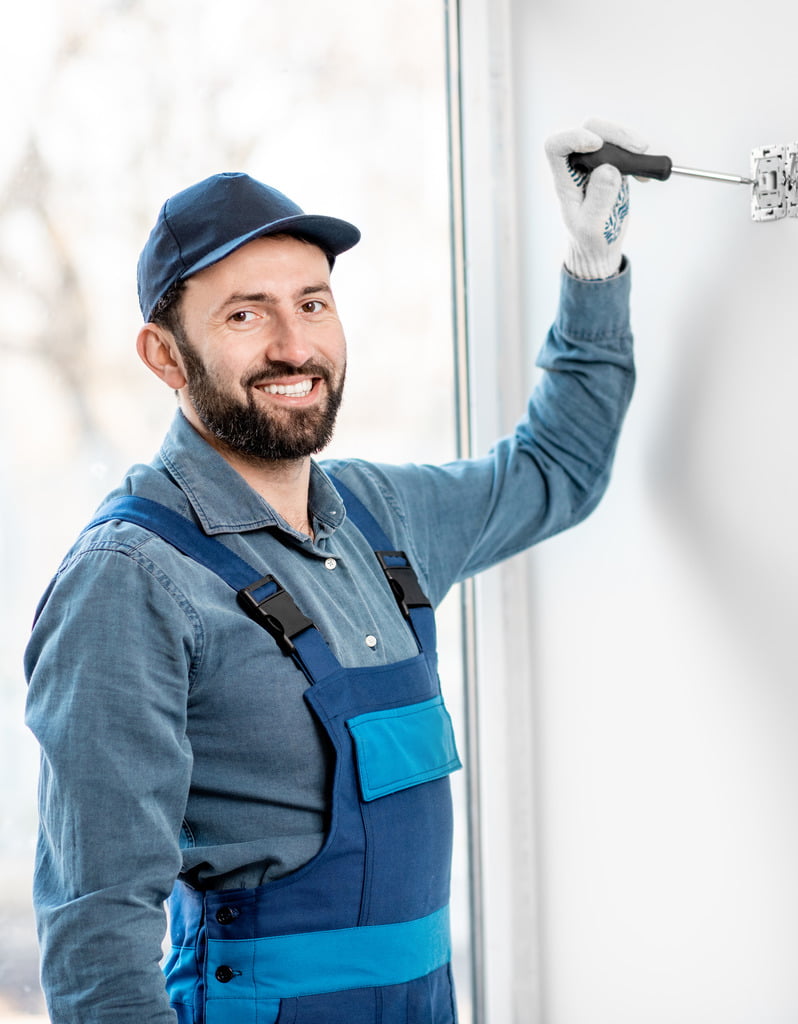 Smiling worker fixing electrical switch