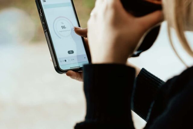 Person checking temperature on smartphone app.